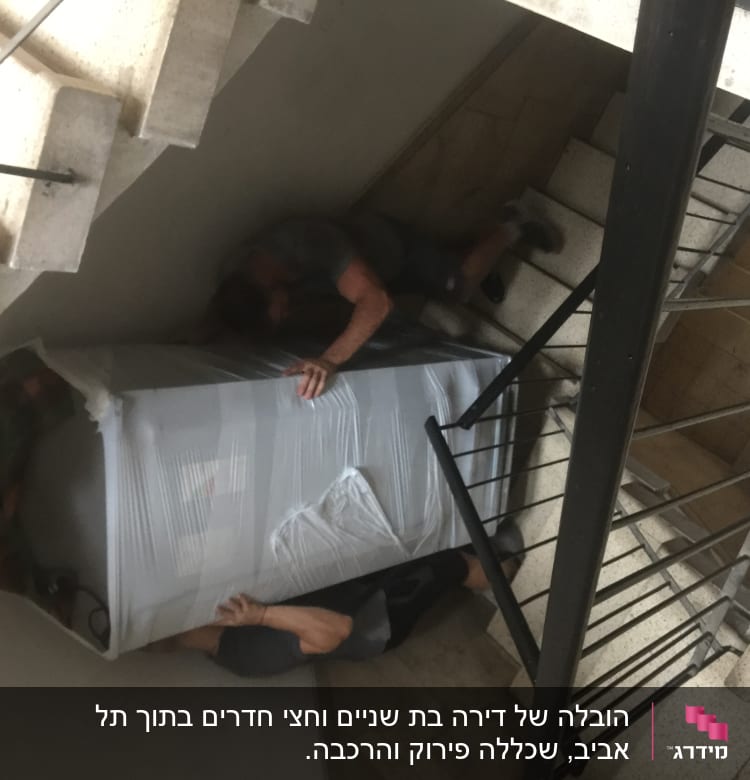 שני אנשים מעבירים מקרר עטוף במדרגות